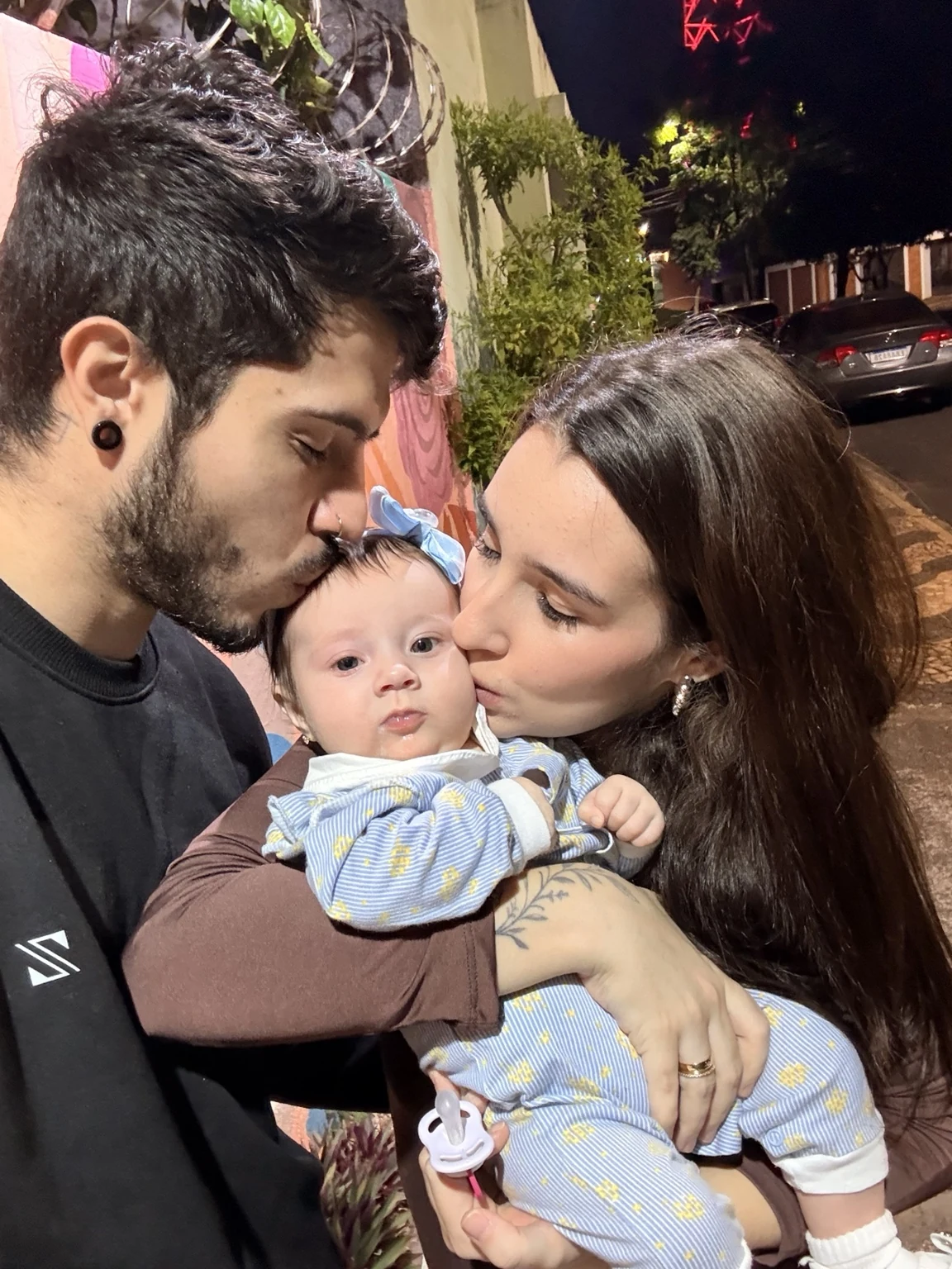 Pai e mãe beijando sua filha em um momento afetivo